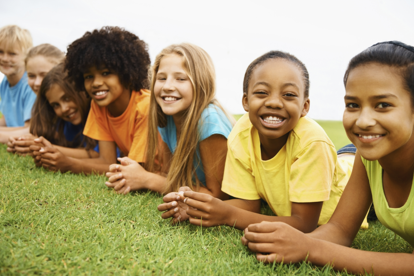 multicultural children laying in grass_0.jpg
